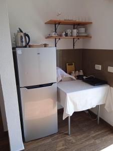 a kitchen with a table and a white refrigerator at Вилла Загора in Neodi