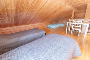 a bedroom with a bed and a chair in a cabin at Ailakka, huoneisto A in Kilpisjärvi