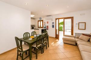 a living room with a table and chairs and a couch at Villa Estrella in Cala en Blanes