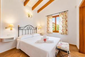 a bedroom with a white bed and a chair at Villa Estrella in Cala en Blanes