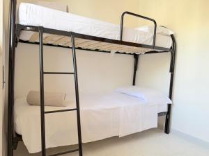 two bunk beds in a room with white sheets at Villetta Chiara in Baia Verde +16 photos