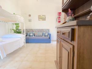 a room with a bedroom with a bed and a couch at Villetta Chiara in Baia Verde