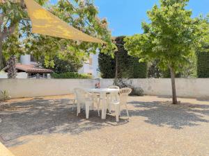 a white table and chairs under a tree at Villetta Chiara in Baia Verde