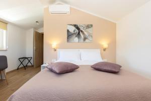 a bedroom with a large bed with two pillows on it at Villa Egli s bazenom in Kršan +23 photos