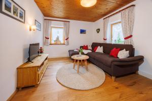 a living room with a couch and a table at Ferienhaus Hallweger inkl. Chiemgaukarte in Ruhpolding