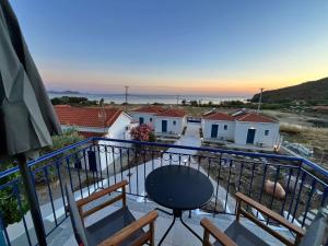 a balcony with chairs and a table and some houses at Ampelitis Studios Lemnos in Agios Ioannis Kaspaka