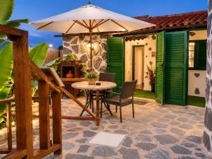 a patio with an umbrella and a table and chairs at TenoHomes La Era de Catuja Getaway in Los Realejos +47 photos