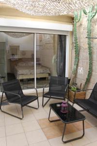 a patio with chairs and a table and a bedroom at Appartement MIFA in Frontignan