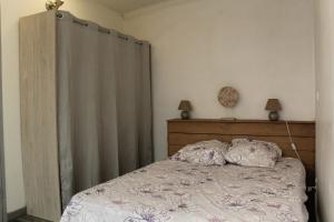 a bedroom with a bed with a wooden headboard at Appartement MIFA in Frontignan