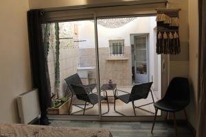 a room with a patio with chairs and a table at Appartement MIFA in Frontignan