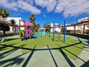 a park with a playground with green grass and trees at Teguisol Breeze en Costa Teguise in Costa Teguise