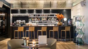 a bar in a restaurant with chairs and a counter at Hotel Palafitte in Neuchâtel