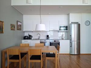a kitchen with a wooden table and a refrigerator at Saimaan Rantavilla Zebra in Imatra