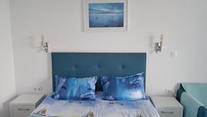 a bedroom with a blue bed with two pillows at Studio Lucian in Douăzeci şi Trei August