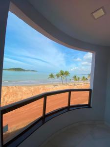 a room with a balcony with a view of the beach at Piúma Palace Hotel in Piúma