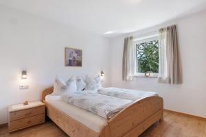a bedroom with a bed with white sheets and a window at Reiterhof Siglgut in Laces