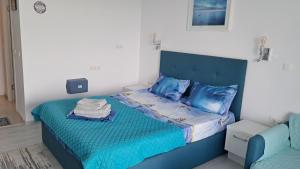 a bedroom with a blue bed with blue pillows at Studio Lucian in Douăzeci şi Trei August