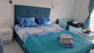 a bedroom with a bed with blue sheets and blue pillows at Studio Lucian in Douăzeci şi Trei August