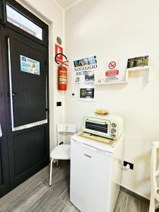 a microwave on top of a refrigerator next to a door at Casa Vacanze VENER - Venosa in Venosa +27 photos