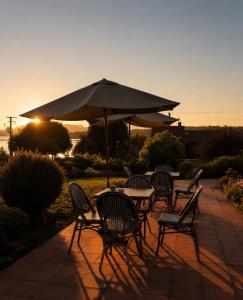 a group of tables and chairs with an umbrella at Hotel El Ciervo in Villarrica