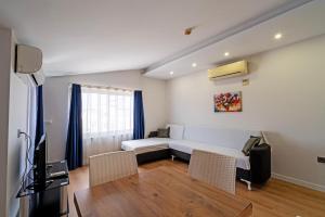 a living room with a couch and a tv at Hey Lara Hotel in Antalya