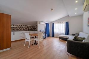 a living room with a table and chairs and a bed at Hey Lara Hotel in Antalya