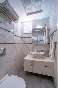 a white bathroom with a sink and a mirror at Hey Lara Hotel in Antalya +26 photos