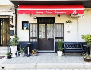 a store front with a red awning and a door at Casa Vacanze VENER - Venosa in Venosa