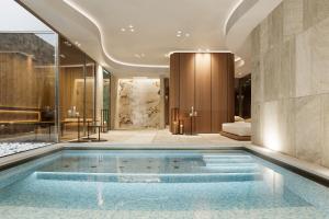 a pool in the middle of a room with a bedroom at Campiglio PLAZA in Madonna di Campiglio
