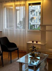 ein Wohnzimmer mit einem Glastisch und einem Stuhl in der Unterkunft Shiraz in Lausanne + 1 Foto