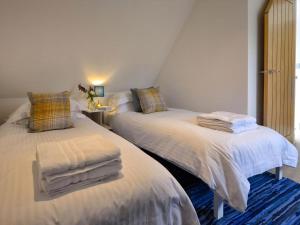 two beds sitting next to each other in a room at Harris Cottage - Uk40056 in Aberfeldy