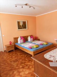 a bedroom with a large bed with pink pillows at Pension Greifswald in Dargelin