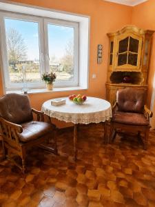 a living room with a table and two chairs at Pension Greifswald in Dargelin +7 photos