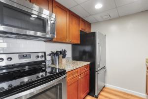 a kitchen with stainless steel appliances and wooden cabinets at Relaxing Arlington Apt - Pool - near Pentagon City in Arlington