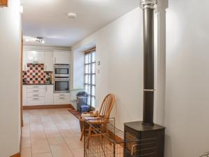 a kitchen with white cabinets and a black stove at Sycamore Cottage - Uk45923 in Ballater