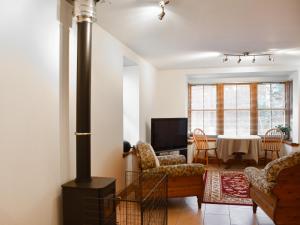 a living room with a wood stove and a table at Sycamore Cottage - Uk45923 in Ballater +12 photos