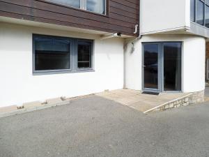 a white house with a door and a patio at Sea Drift in West Bay