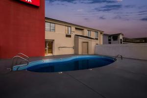 a blue swimming pool in front of a building at Red Roof Inn Branson in Branson
