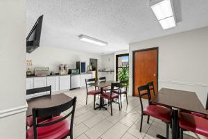 a kitchen and dining room with tables and chairs at Red Roof Inn Branson in Branson