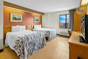 a hotel room with two beds and a television at Red Roof Inn Branson in Branson