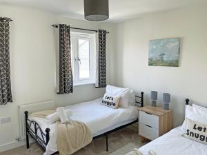 a bedroom with two beds and a window at Wagtails in Dartmouth