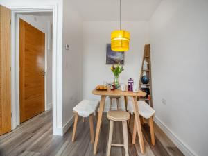 a dining room with a table and stools at Wagtails in Dartmouth