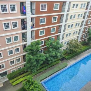 an apartment building with a swimming pool in front of it at Condo Tulip Square at Aomnoi in Ban Khlong Om Noi