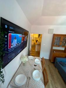 a living room with a table with a tv on the wall at Casa Tre Fiori 3 in Mignanego