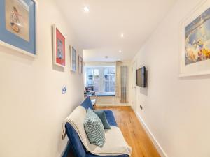a living room with a blue couch and a tv at Town Square Apartment - Uk45611 in Alnwick