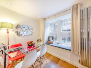 a dining room with a glass table and chairs and a window at Town Square Apartment - Uk45611 in Alnwick
