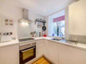 a kitchen with white cabinets and a sink and a window at Town Square Apartment - Uk45611 in Alnwick +7 photos