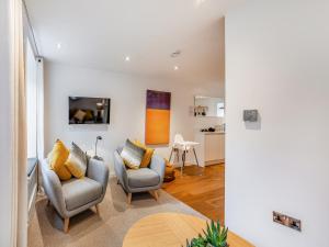 a living room with two chairs and a tv at Town Square House - Uk45610 in Alnwick