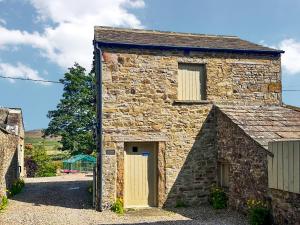 an old stone house with a garage at The Owlery At Aysgarth in Aysgarth