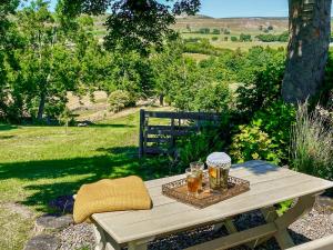 a picnic table with two glasses of beer on it at The Owlery At Aysgarth in Aysgarth +9 photos